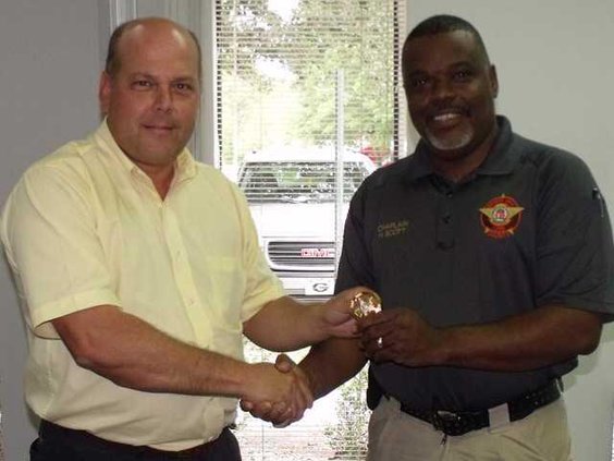 Sheriff Nobles presents badge to Chaplain Herman Scott