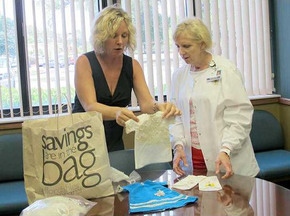 Maryann Wilson showing a burial gown to RN Jan St. John