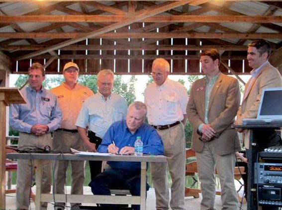 Deal signs legislation with legislators behind him